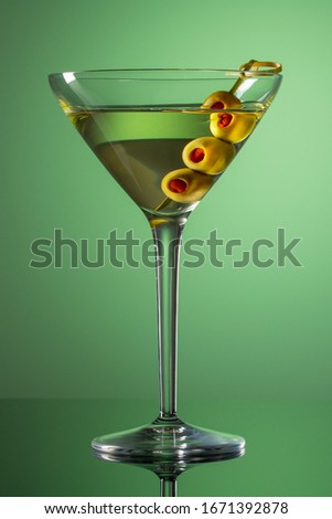 Glass of Martini with olives. Extra dry vermouth martini. Alcohol cocktail on green background.  Royalty-Free Stock Photo #1671392878