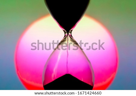Hourglass on the background of a sunset. The value of time in life. time measuring tool
