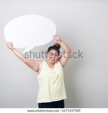 portrait of smiling plump asian woman with speech bubble with empty space for text studio shot isolated standing against light gray Banner background