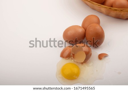 A broken chicken egg and scattered eggs on a white background. Close up.