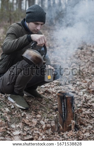 Tourist makes tea in the forest on a Swedish candle
