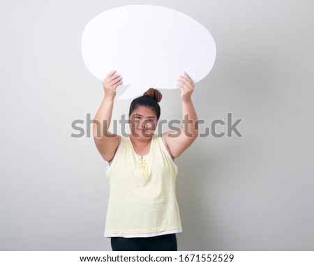 portrait of smiling plump asian woman with speech bubble with empty space for text studio shot isolated standing against light gray Banner background