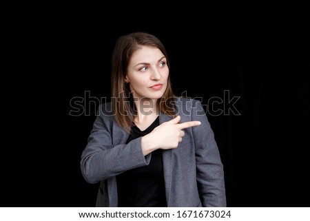 A cute young woman pointing right up with her finger.