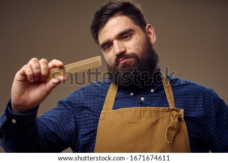 man in yellow aprons and comb in hand