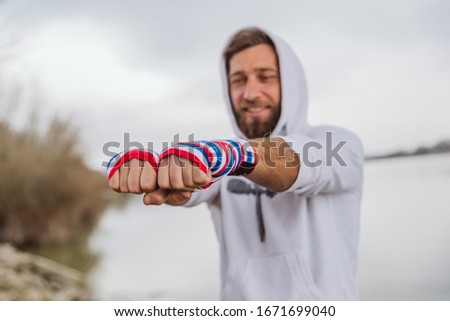 Boxer with bandages on his hands, getting ready for outdoor training