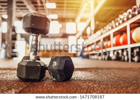 Sports equipment in gym. Dumbbells on the floor. Closeup image of a fitness equipment in gym. Gym weights on the floor. Fitness room in the morning