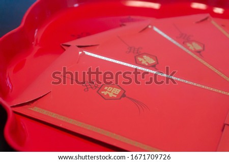 Chinese New Year traditional Red envelope in the plate with lucky money inside 