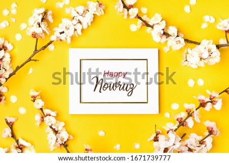 White photo frame and sprigs of the apricot tree with flowers on yellow background. Text Happy Nawruz. The concept of spring came Top view. Flat lay Holiday card