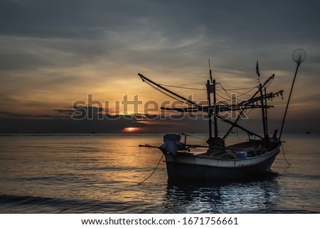 Thai fishing boat used as a vehicle for finding fish in the during beautiful twilight in the sea. 