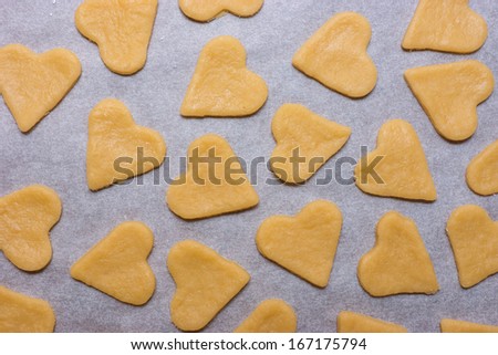 Ready to bake cookies in the shape of heart on baking paper