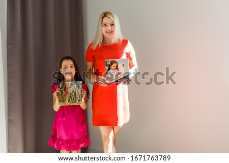 mother and daughter hold photo canvas at home