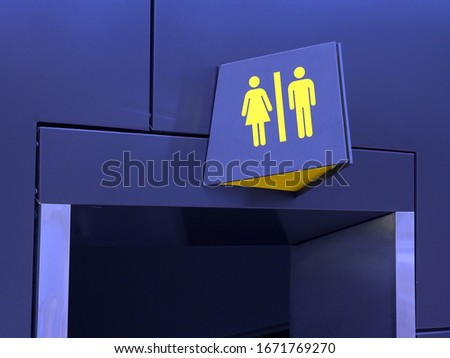 pointer over the door male and female toilet yellow symbols on a blue wall