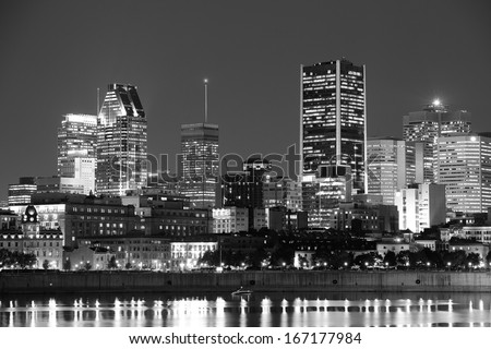 Montreal over river at dusk with city lights and urban buildings in black and white
