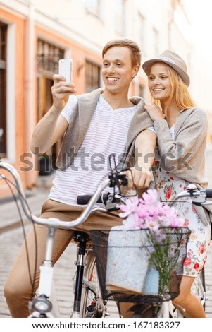 summer holidays, bikes, love, relationship, navigation, gps and dating concept - smiling couple with bicycles and smartphone in the city