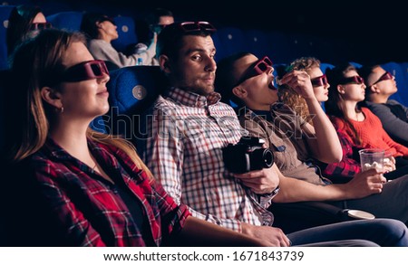 The guy is recording a pirated movie in a movie theater. Stock photo of a group of people in the cinema.