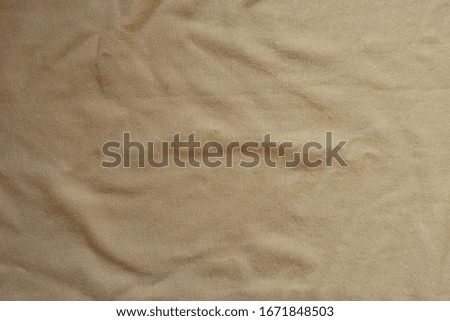 Rumpled beige cotton jersey fabric from above