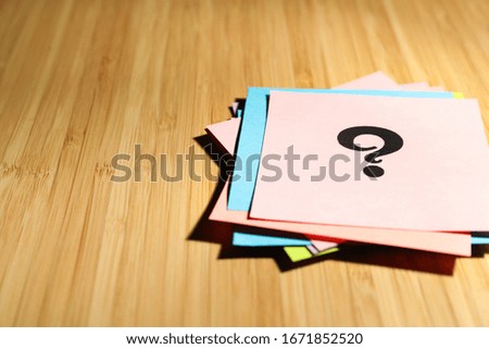 Paper cards with question mark on wooden background, closeup. Space for text