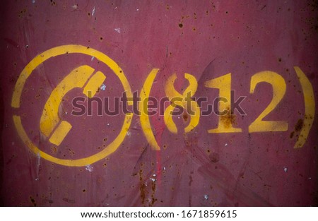 
Metallic textured rusty wall of red color with numbers and phone icon