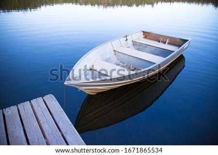 two rowboat floating in calm Sequoia lake next to deck with beautiful reflection of sky Royalty-Free Stock Photo #1671865534
