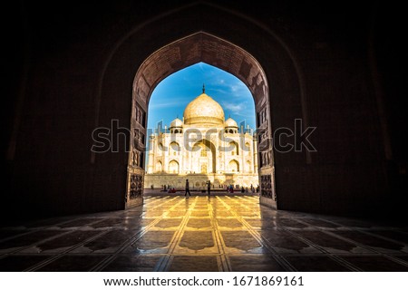 Taj Mahal in Agra city is an ivory-white marble mausoleum on the banks of the Yamuna river in Uttar Pradesh India. Taj Mahal views while sunset with clear blue sky. Architecture of Taj Mahal. - Image Royalty-Free Stock Photo #1671869161