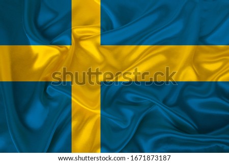 photo of the national flag of the state of Sweden on a luxurious texture of satin, silk with waves, folds and highlights, close-up, copy space, illustration