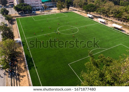Aerial drone top view of mini football soccer field with playing people