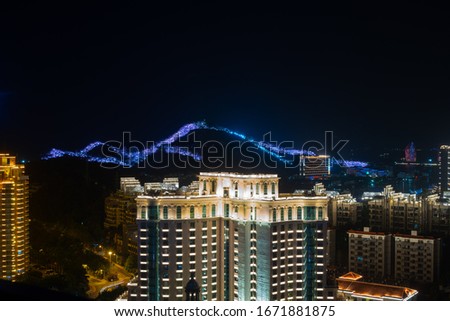 Night city view, neon lighted buildings aerial photo, China Hainan