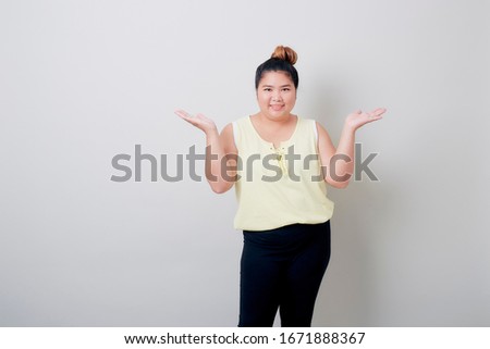 Beautiful plump Young Asian Woman smiling showing something with hands up isolated on white background textured for banner design