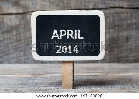 April 2014 on Small wooden framed blackboard with wooden background
