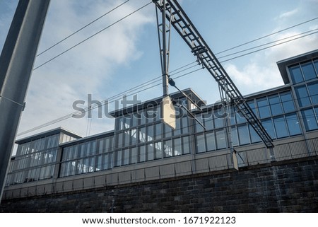 Small white empty sign on modern office building with glass exterior and cloudy sky background , copy space