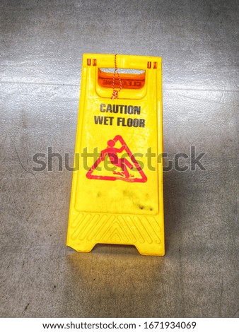 Yellow warning signs on the ground, red books on the cement floor