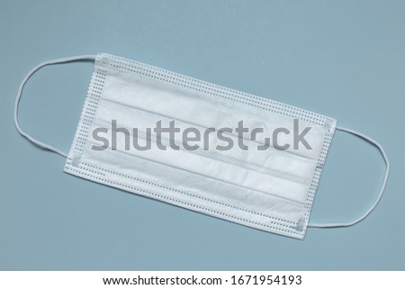 Surgical mask with rubber straps. A three-layer surgical mask for covering the mouth and nose. Bacterial mask procedure. Concept of protection.