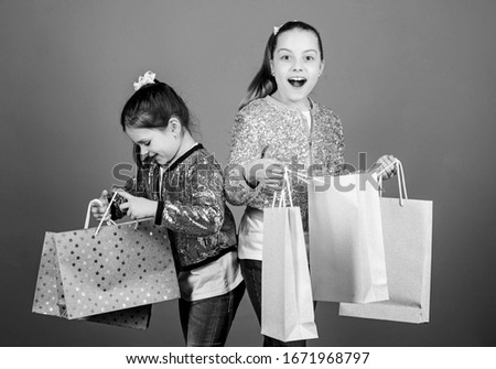 Shopping day. Children bunch packages. Kids fashion. Girls sisters friends with shopping bags violet background. Because image is everything. Shopping and purchase. Black friday. Sale and discount.