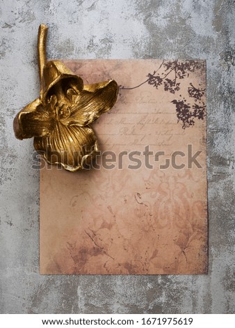 Mockup vintage paper sheet and golden orchid flower. Top view. mock up for word.