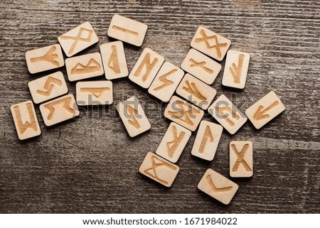 Top view of signs on runes on wooden background