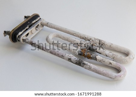  limescale and deposits on the heating element of a washing machine on a white background Royalty-Free Stock Photo #1671991288