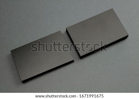 2 stack of black blank textured business cards on dark paper background, us size 3.5 x 2 inches, as template for design presentation.