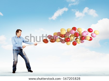 Image of adult man holding bunch of colorful balloons