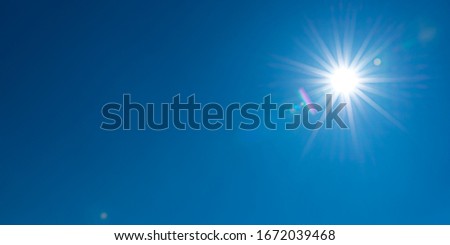 Sun, sunbeams against blue sky - cloudless sky. Photography with Lense flair effect Royalty-Free Stock Photo #1672039468