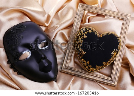 Decorative black heart and mask, on color fabric