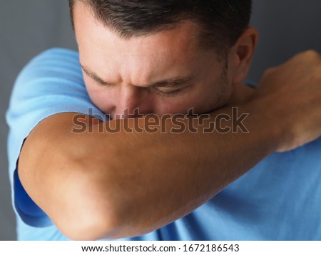 Close-up. Caucasian male coughs in his elbow. Correct sneezing. Concept of stop spread of the virus. Royalty-Free Stock Photo #1672186543