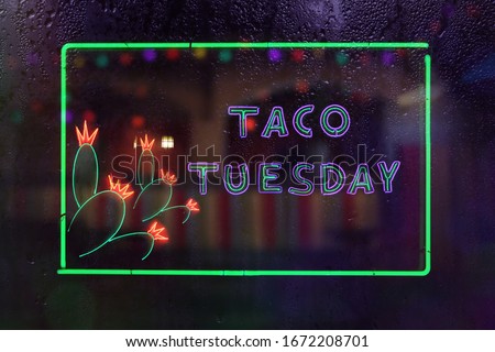 Taco Tuesday Neon Sign in Rainy Window of Mexican Restaurant 