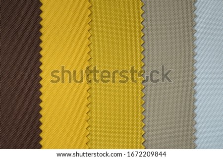 Samples of fabrics in pastel colors. brown and yellow piece of fabric with texture. Lightweight fabric made of synthetic fibres (nylon or polyester) of a certain structure with a special coating.
