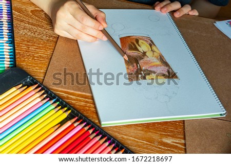 Hand drawing. Pencilcolor art. Woman’s hand in the picture coloring.