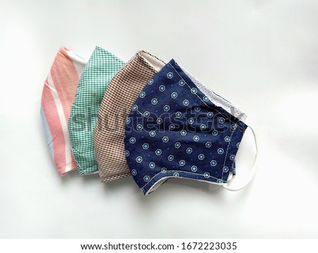 The half folded cloth face masks double layered which can be washed and reused many times for wearing to protect against Covid-19 virus or Corona virus and PM2.5 dust when out in public, new normal.