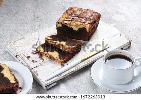 brownie with cream cheese in rustic tray on white background.sliced marble cheese brownies with a cup of coffe
brownie with cream cheese isolated on white background 
