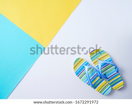 Colorful background with yellow, blue and flip flops. Space for text, flat lay.