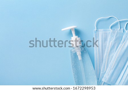Sanitizer gel or antibacterial soap and face mask for coronavirus preventive measure, top view Royalty-Free Stock Photo #1672298953