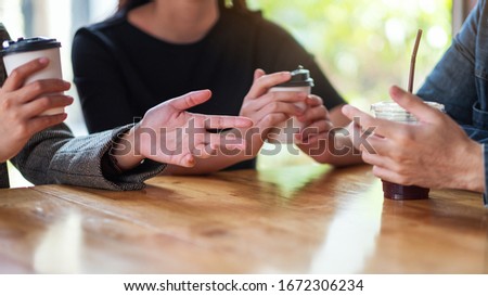 Closeup image of people enjoyed talking and drinking coffee together in cafe