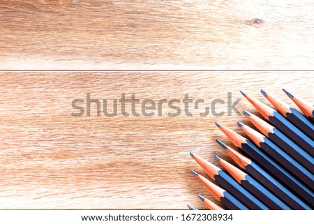 black pencils isolated on wood surface background.Close up.